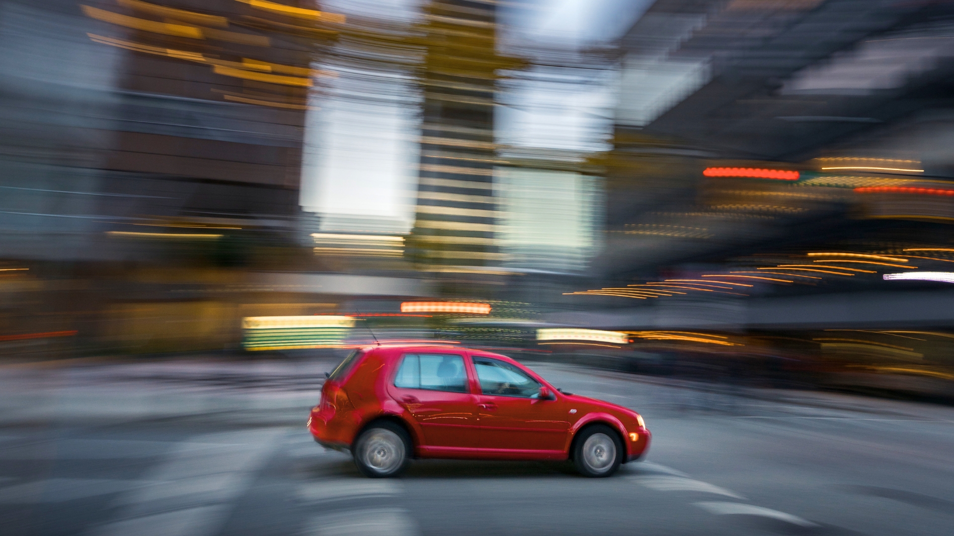 Imagen de un coche rojo paseando por ciudad a modo decorativo para la información 